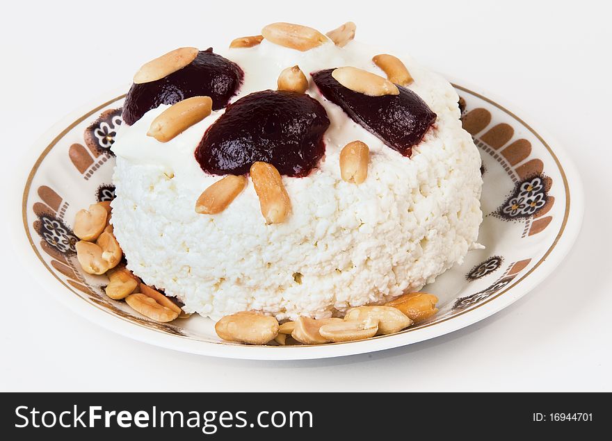 Dairy breakfast, cottage cheese on a plate with jam and nuts on white  background