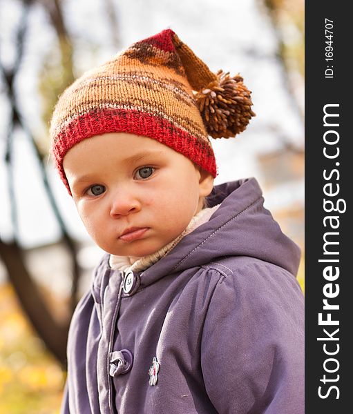 Beautiful baby in a funny hat outdoor against autumn nature. Beautiful baby in a funny hat outdoor against autumn nature