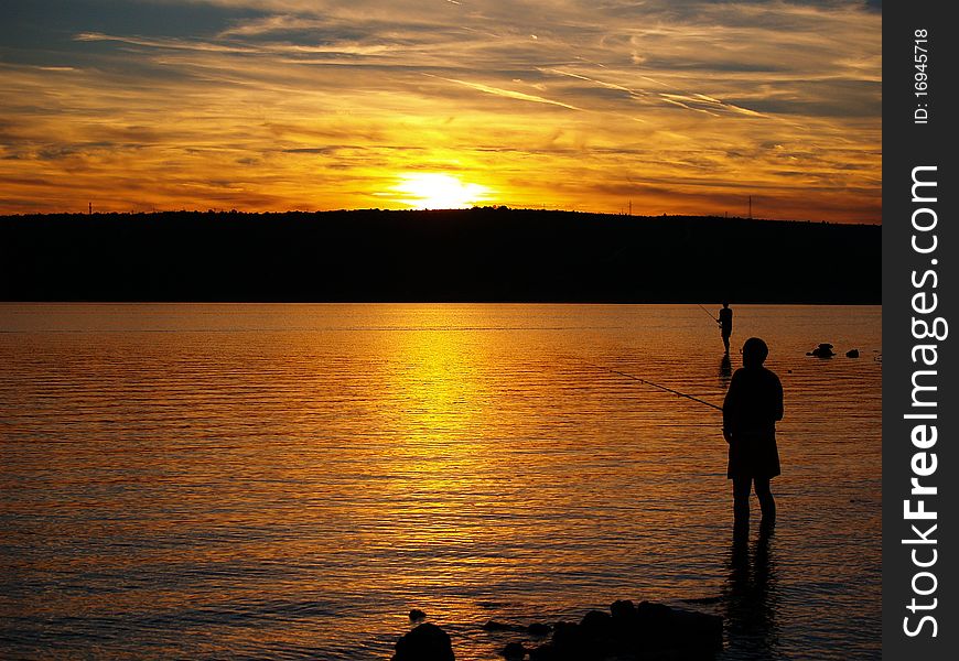 Man fishing on the coast of sea in sunset. Man fishing on the coast of sea in sunset