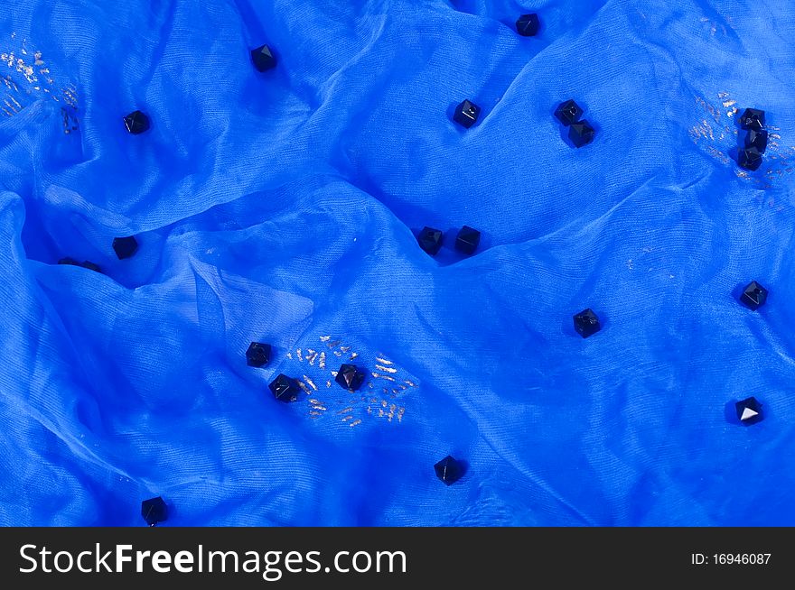 Black beads placed on blue textile. Black beads placed on blue textile