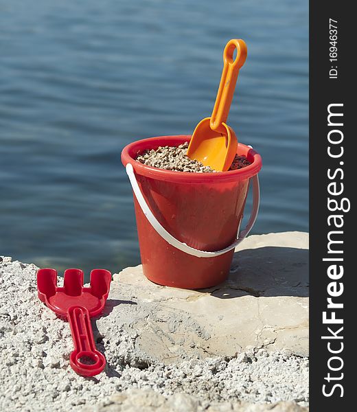 Bucket with sand on the sea coast