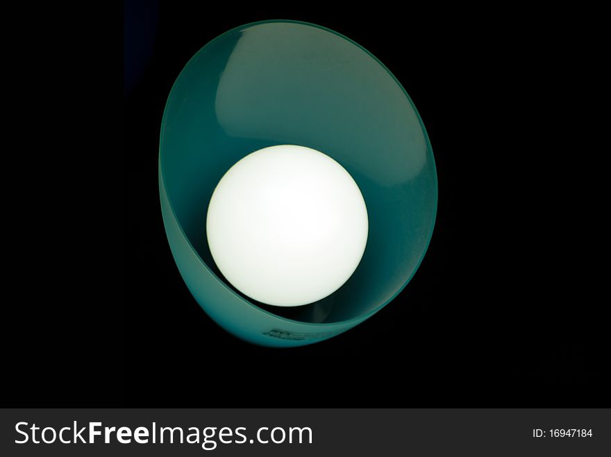 A single hooded florescent light on a dark background. A single hooded florescent light on a dark background.