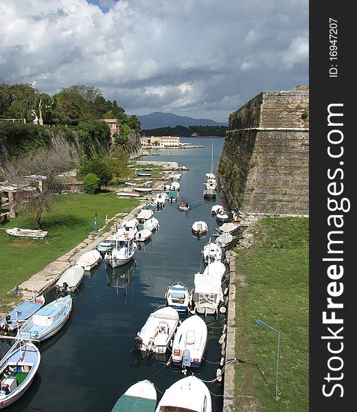 Canal and boats near the old fortress in Corfu island. Canal and boats near the old fortress in Corfu island