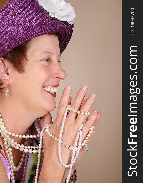 Adult female wearing a purple hat and pearls. Adult female wearing a purple hat and pearls