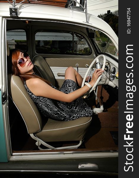 A girl sitting inside an antique car with sun glasses. A girl sitting inside an antique car with sun glasses