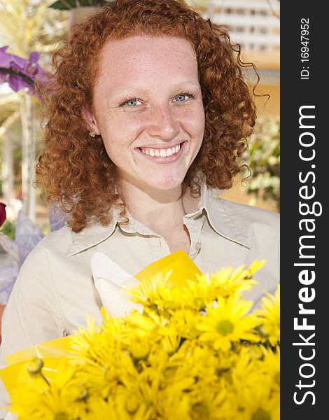 Happy woman holding a bunch of yellow flowers