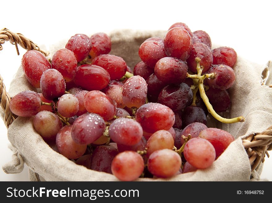 Red wine grapes with water drops in the basket