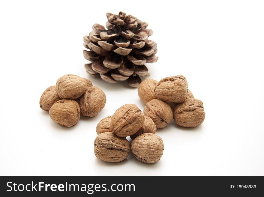 Walnuts stacked with pine cones