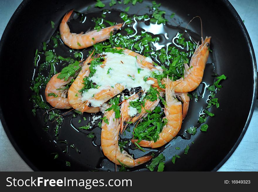 A cook prepares shrimps in an Italian restaurant.