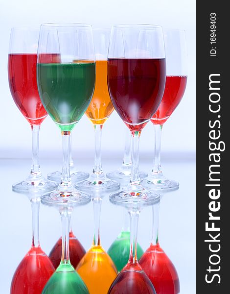 Colored glasses arranged on a glass substrate. Mirror was used as background. Colored glasses arranged on a glass substrate. Mirror was used as background