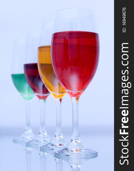 Colored glasses arranged on a glass substrate. Mirror was used as background. Colored glasses arranged on a glass substrate. Mirror was used as background