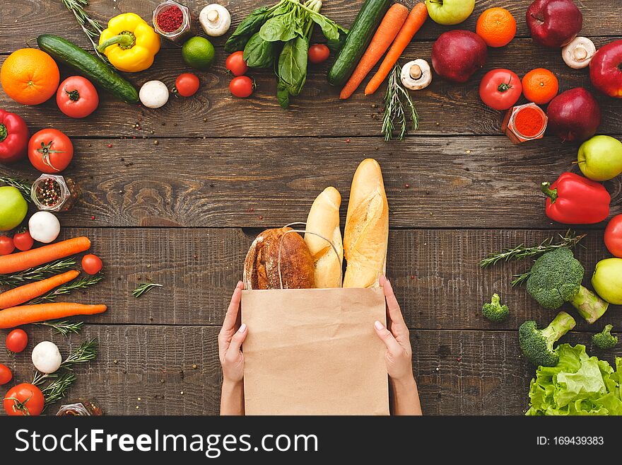 Woman Hands With Bread Near Raw Organic Vegetables On Table