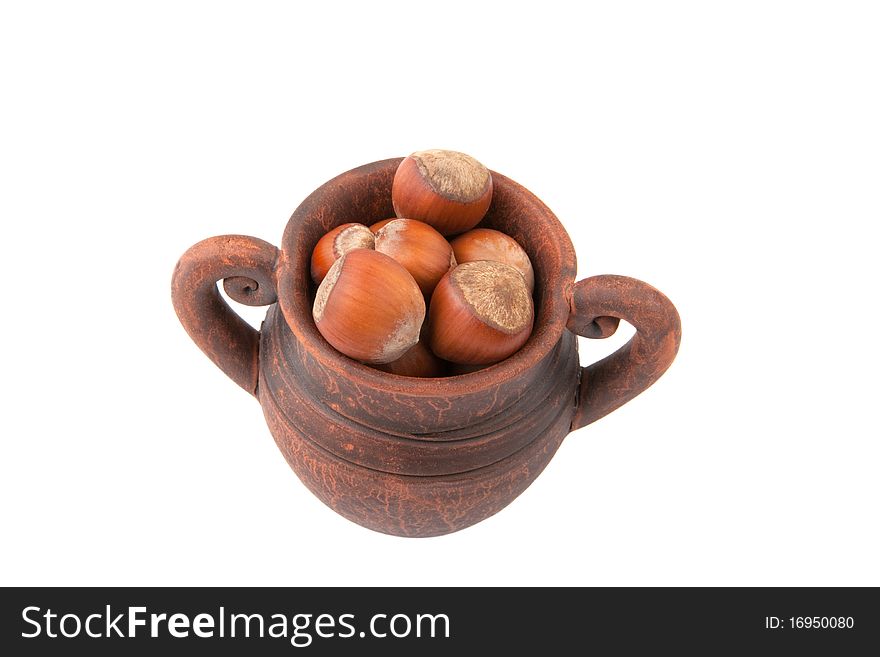 Clay jug With nuts on a white background