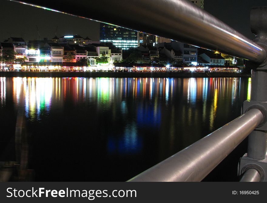 Reflection of modern buildings at Singapore river at night.