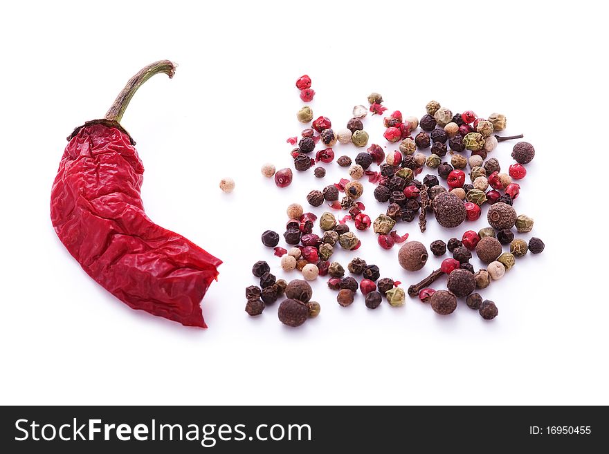 Red chili pepper and assorted peppercorns isolated on white. Red chili pepper and assorted peppercorns isolated on white