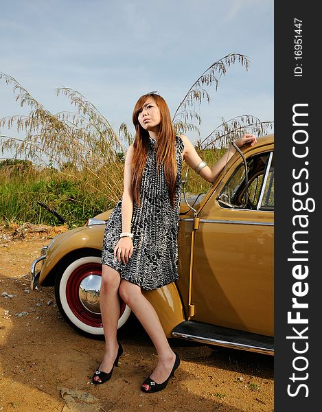 Girl and car with blue sky as background