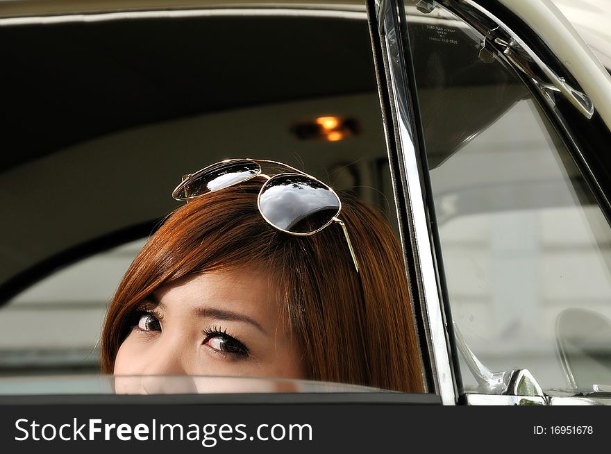 Girl peeping from inside of an antique car