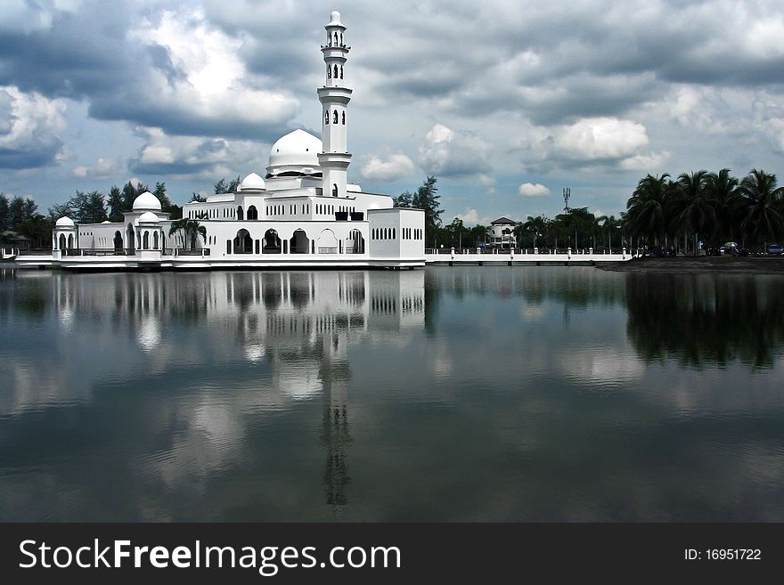 A state mosque built of white marble in Malaysia. Towering minarets with onion-shaped dome amidst landscaped lake. A state mosque built of white marble in Malaysia. Towering minarets with onion-shaped dome amidst landscaped lake.