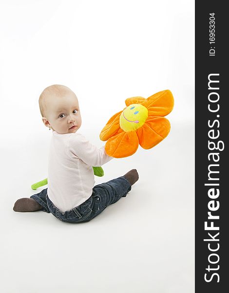 Little girl with flower sit, on white background.
