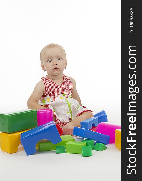 Infant with plastic cubes, on white background.