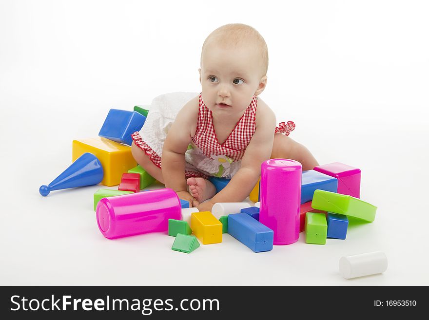 Girl plaies with plastic cubes, on white background.