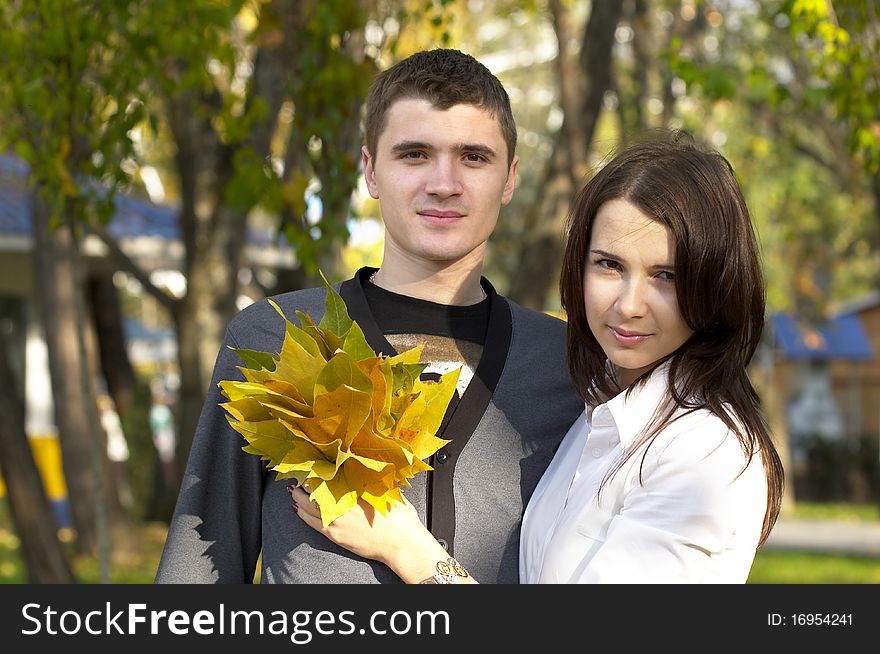 Young couple with autumn leas over defocused background. Young couple with autumn leas over defocused background