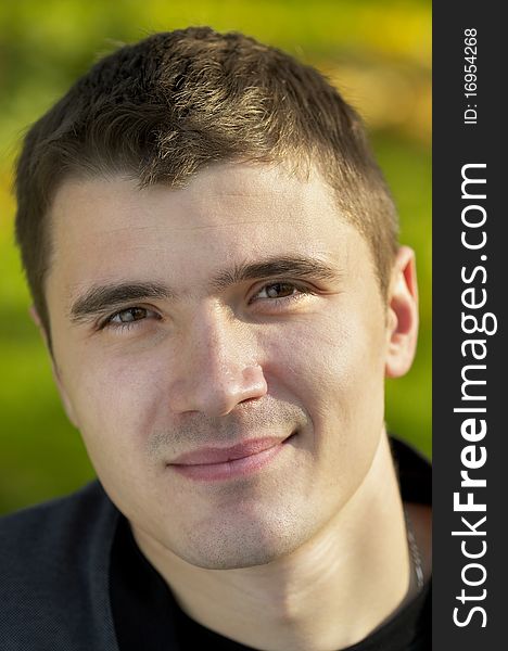 Young man portrait over light autumn defocused background