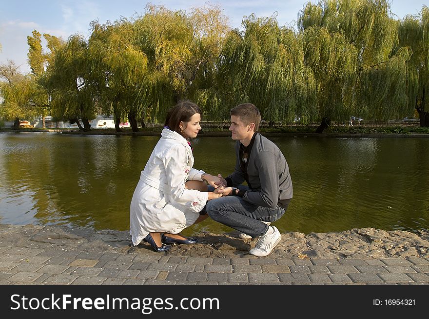 Young couple sitting in the autumn city park (defocused background). Young couple sitting in the autumn city park (defocused background)