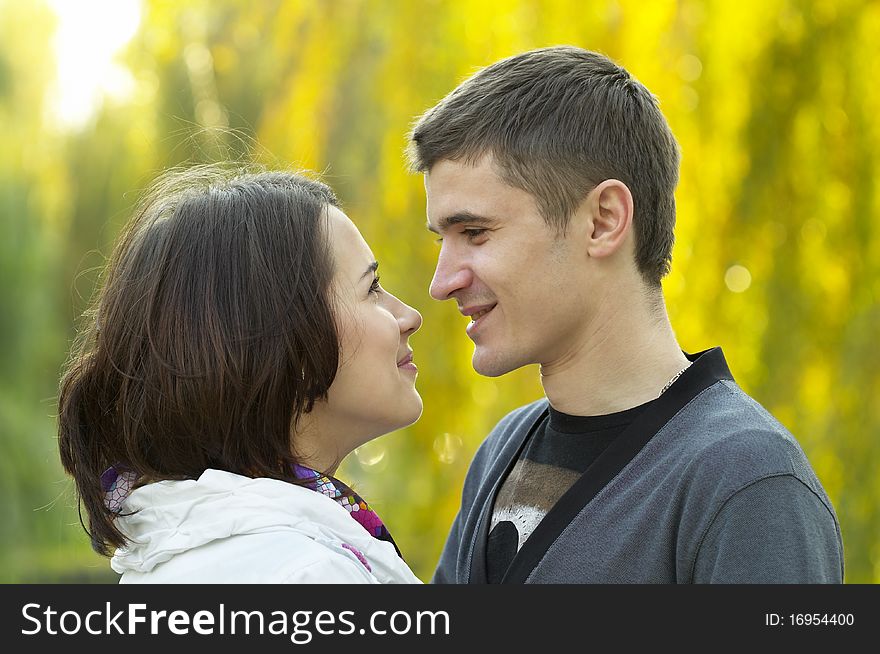 Young couple looking at each other eyes over defocused background. Young couple looking at each other eyes over defocused background