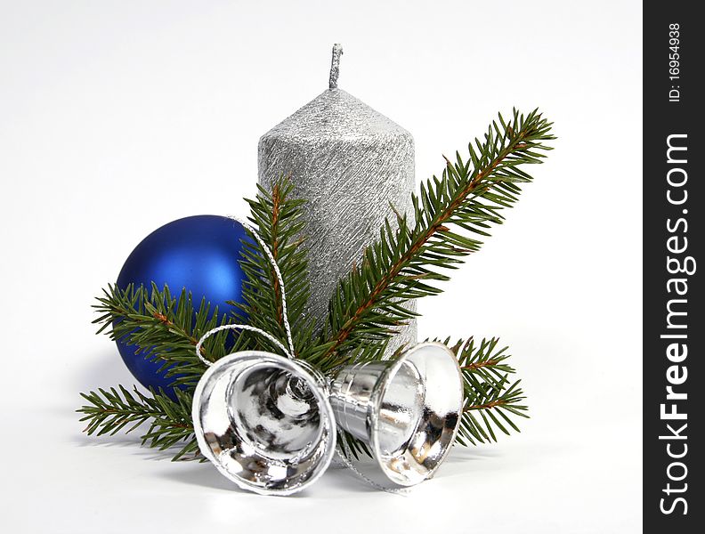 Silver candle with the twig of the spruce and bells