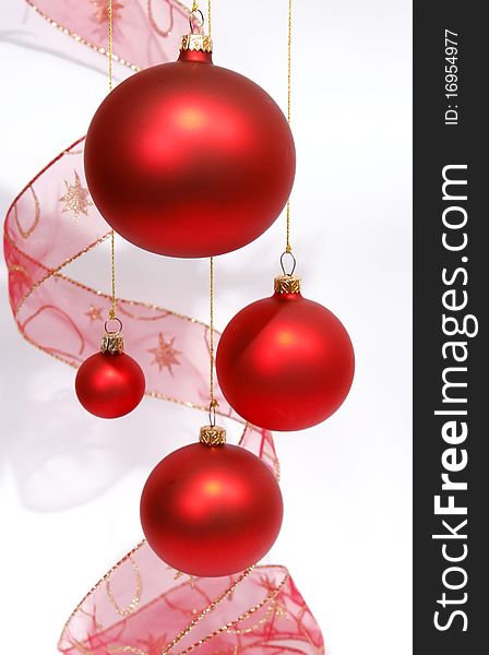 Hanging red glass balls with the ribbon on the white background. Hanging red glass balls with the ribbon on the white background