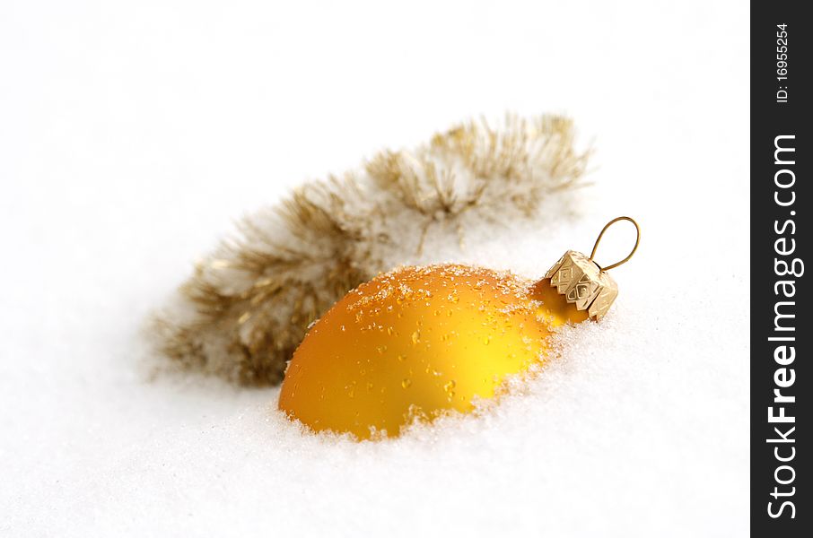 Yellow glass ball being in the snow