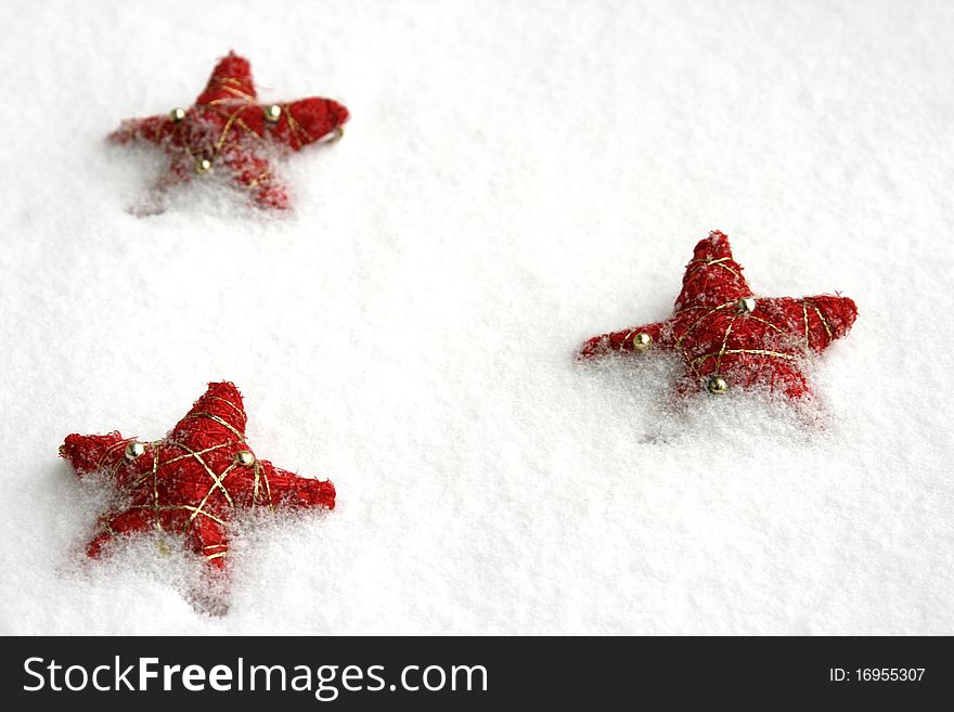 Red christmas stars on the snow