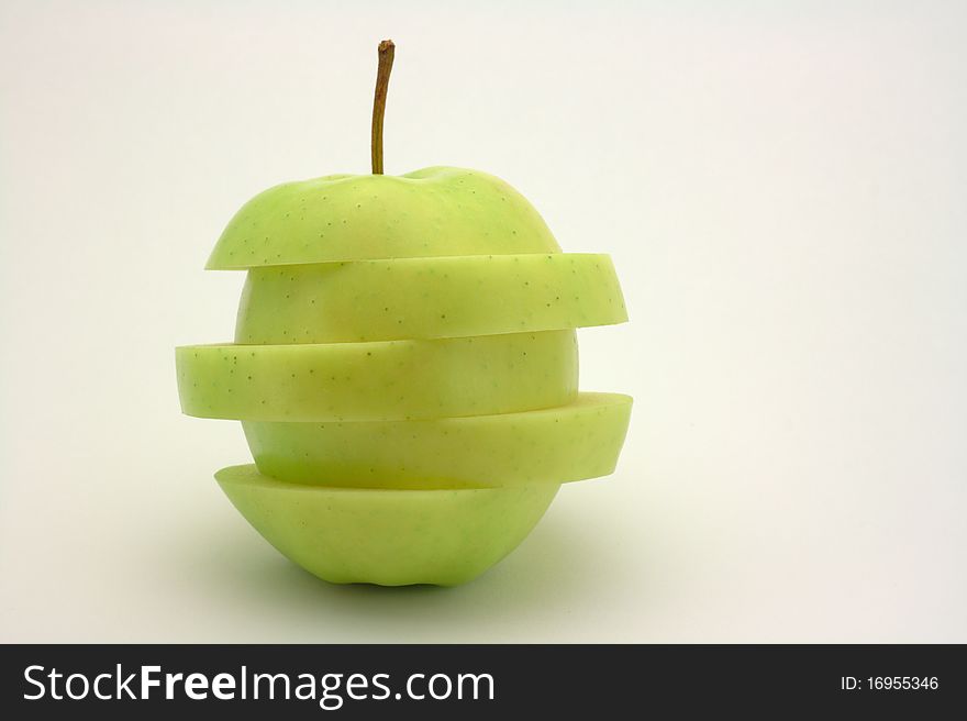 Green apple sliced to five pieces. Each piece is shifted a bit. Green apple sliced to five pieces. Each piece is shifted a bit.