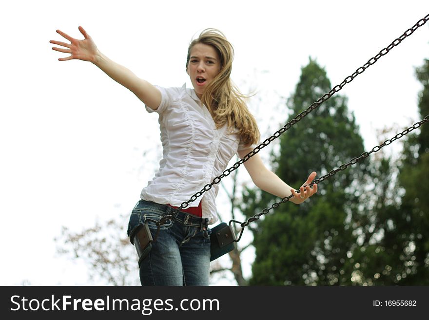 Happy girl on swing with arm extended toward the sky. Happy girl on swing with arm extended toward the sky