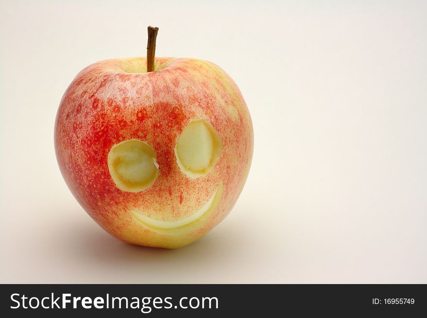 Smiling face carved into red apple. Smiling face carved into red apple