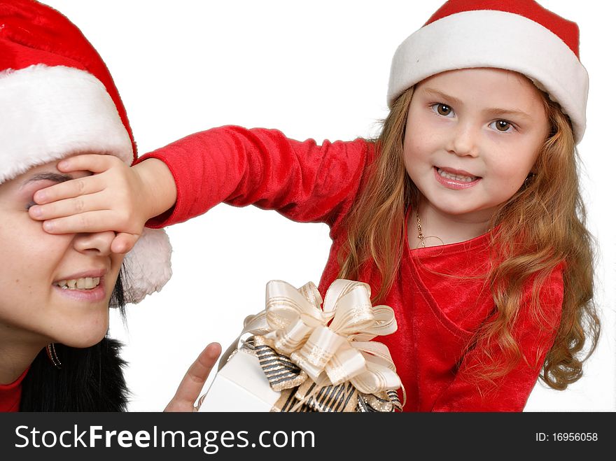 Little girl gives a holiday gift in red box with white ribbon.