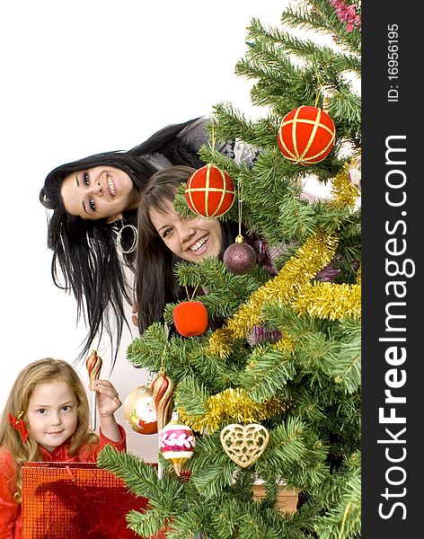 Three young happy women decorating the Christmas tree. Studio shot. White background