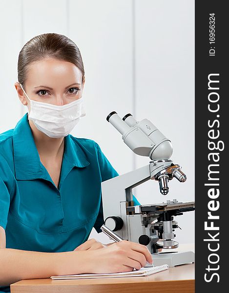 Female medical doctor using microscope in a laboratory. Female medical doctor using microscope in a laboratory