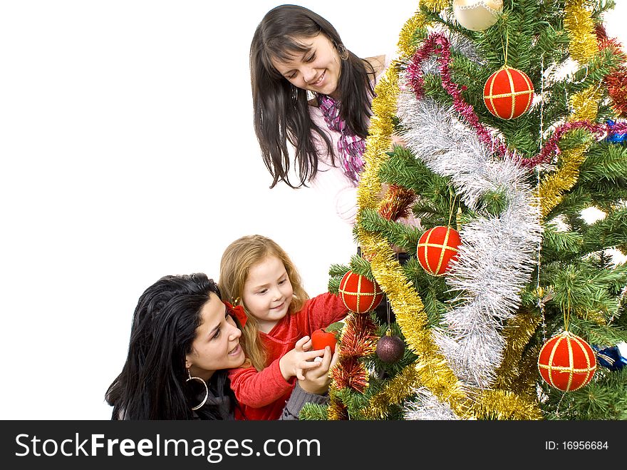 Three young happy women decorating the Christmas tree. Studio shot. White background