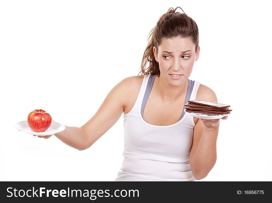 A woman is deciding between chocolate and fruit. A woman is deciding between chocolate and fruit.