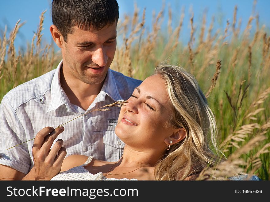 Pair young, enamoured, the man and the woman, sit on a grass. Pair young, enamoured, the man and the woman, sit on a grass