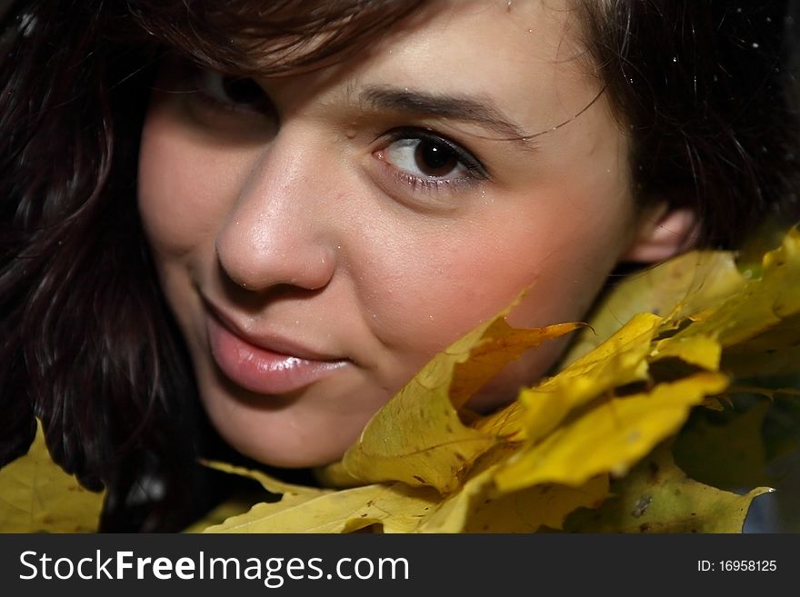 Close-up portrait of woman in red autumn leaves