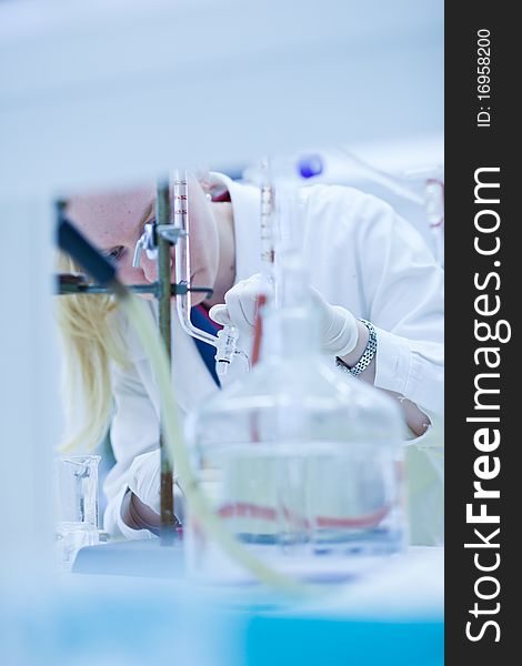 Portrait of a female researcher carrying out research in a chemistry lab (color toned image; shallow DOF)