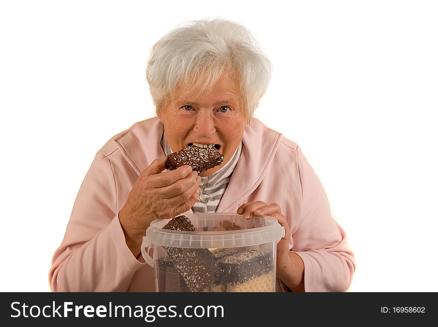 Senior lady is eating chocolate. Senior lady is eating chocolate