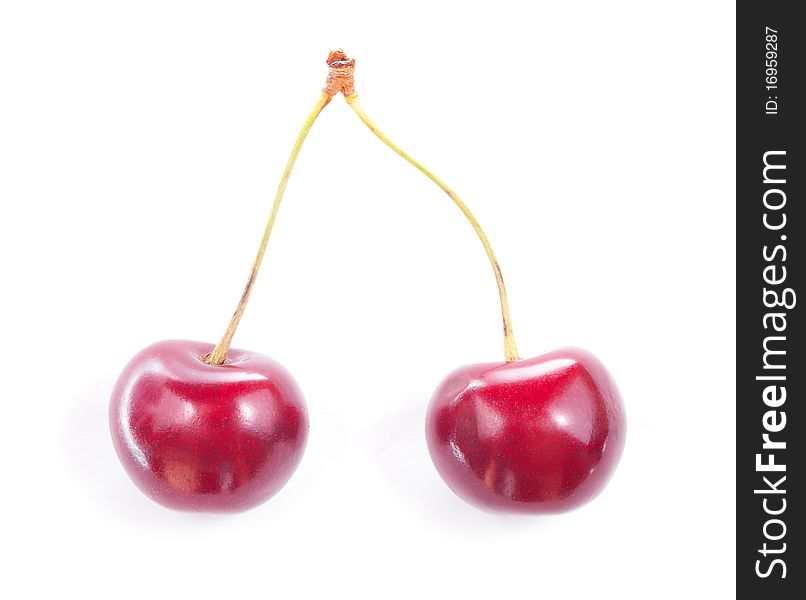 Two colorful red cherries isolated on white background. Two colorful red cherries isolated on white background.