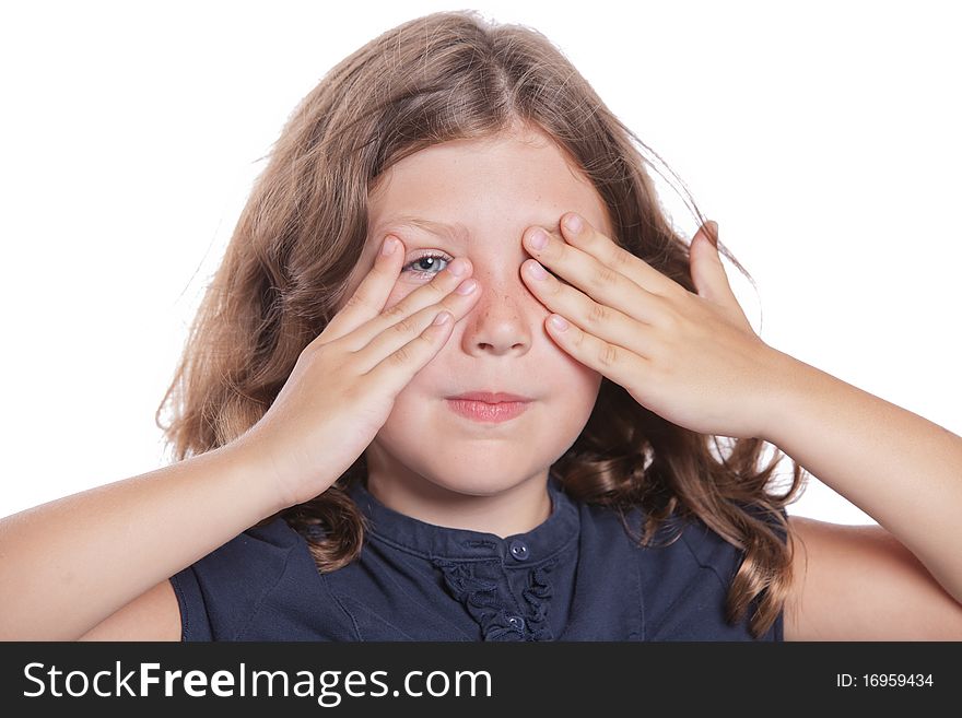 A cute little girls peeks through her fingers while covering her eyes. A cute little girls peeks through her fingers while covering her eyes