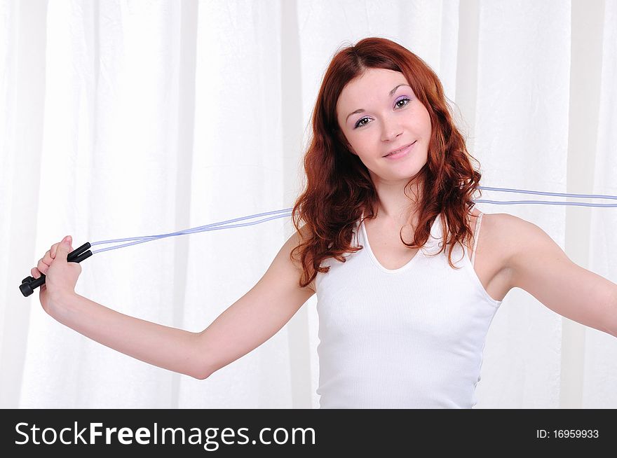 Young girl doing exercises with skipping rope