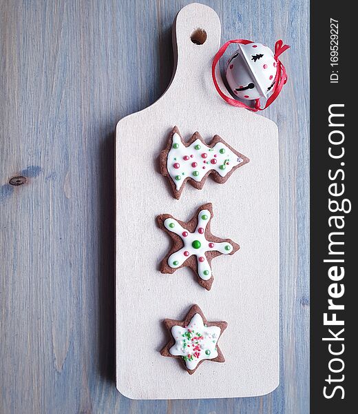 Three colorful, homemade, iced gingerbread cookies on a cutting board. Three colorful, homemade, iced gingerbread cookies on a cutting board