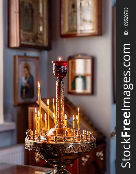 Decoration of the Orthodox Church, Church candlestick with burning candles, icons in the background in the background